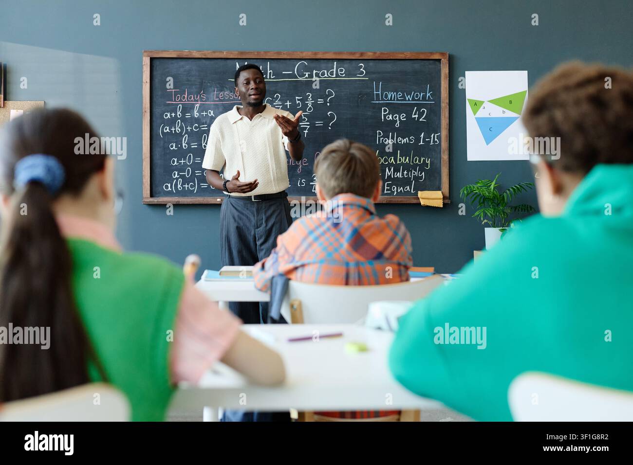 Black Male Teacher Explaining Math Lesson to Elementary Students Stock Photo