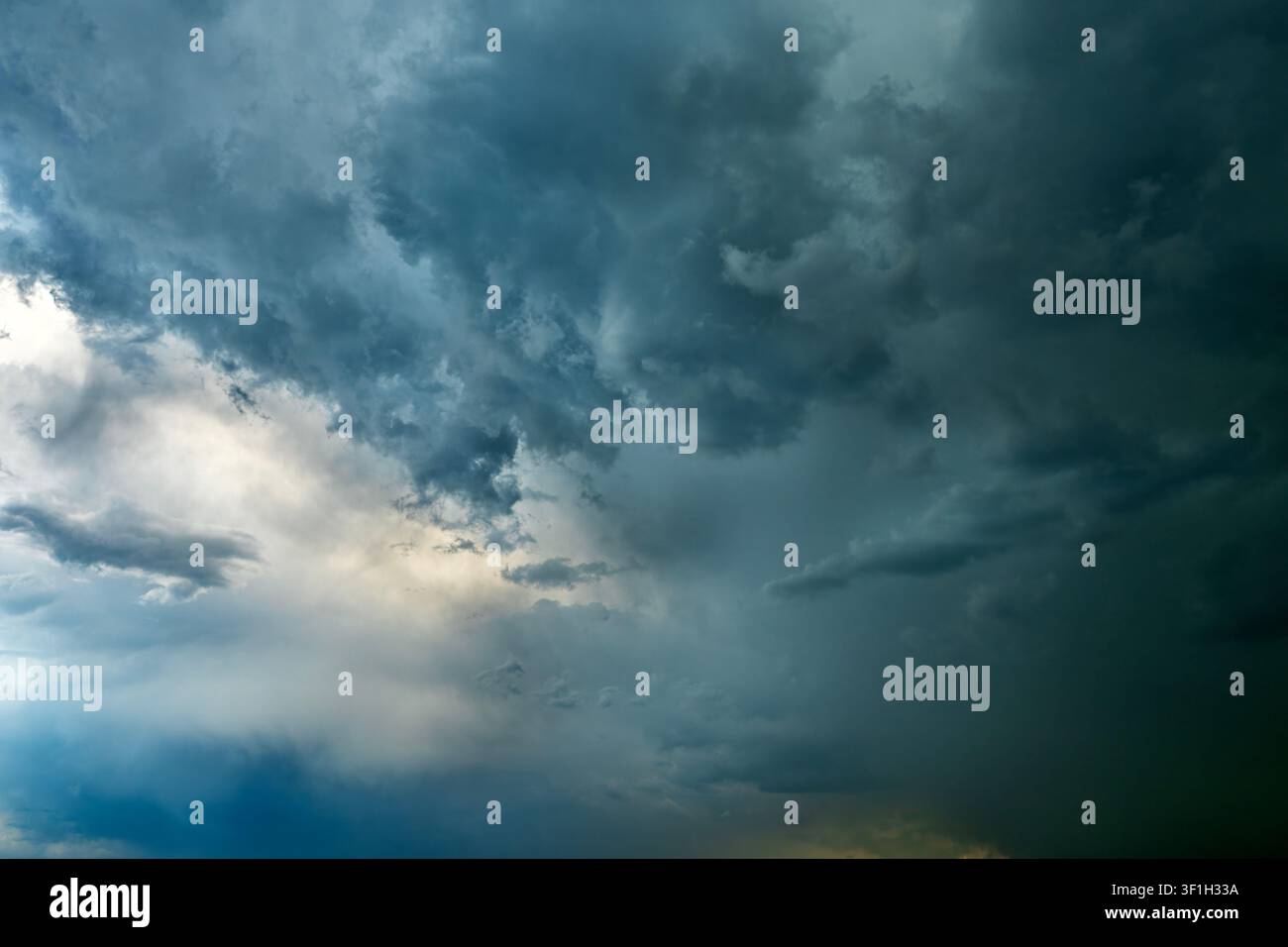 Dramatic storm clouds spreading across blue sky before rain Stock Photo