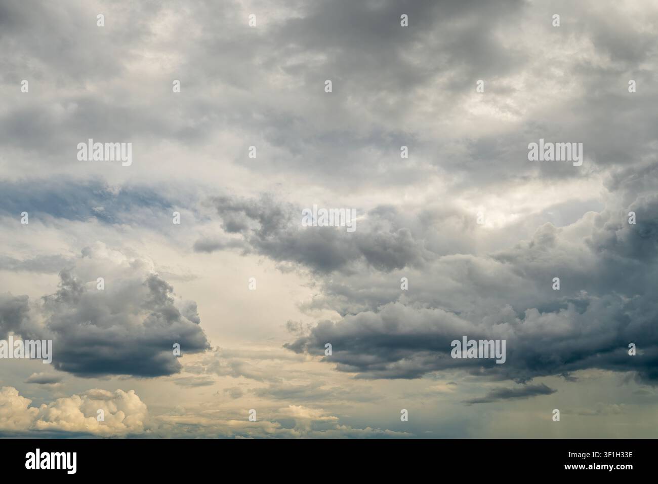 Dramatic storm clouds spreading across blue sky before rain Stock Photo