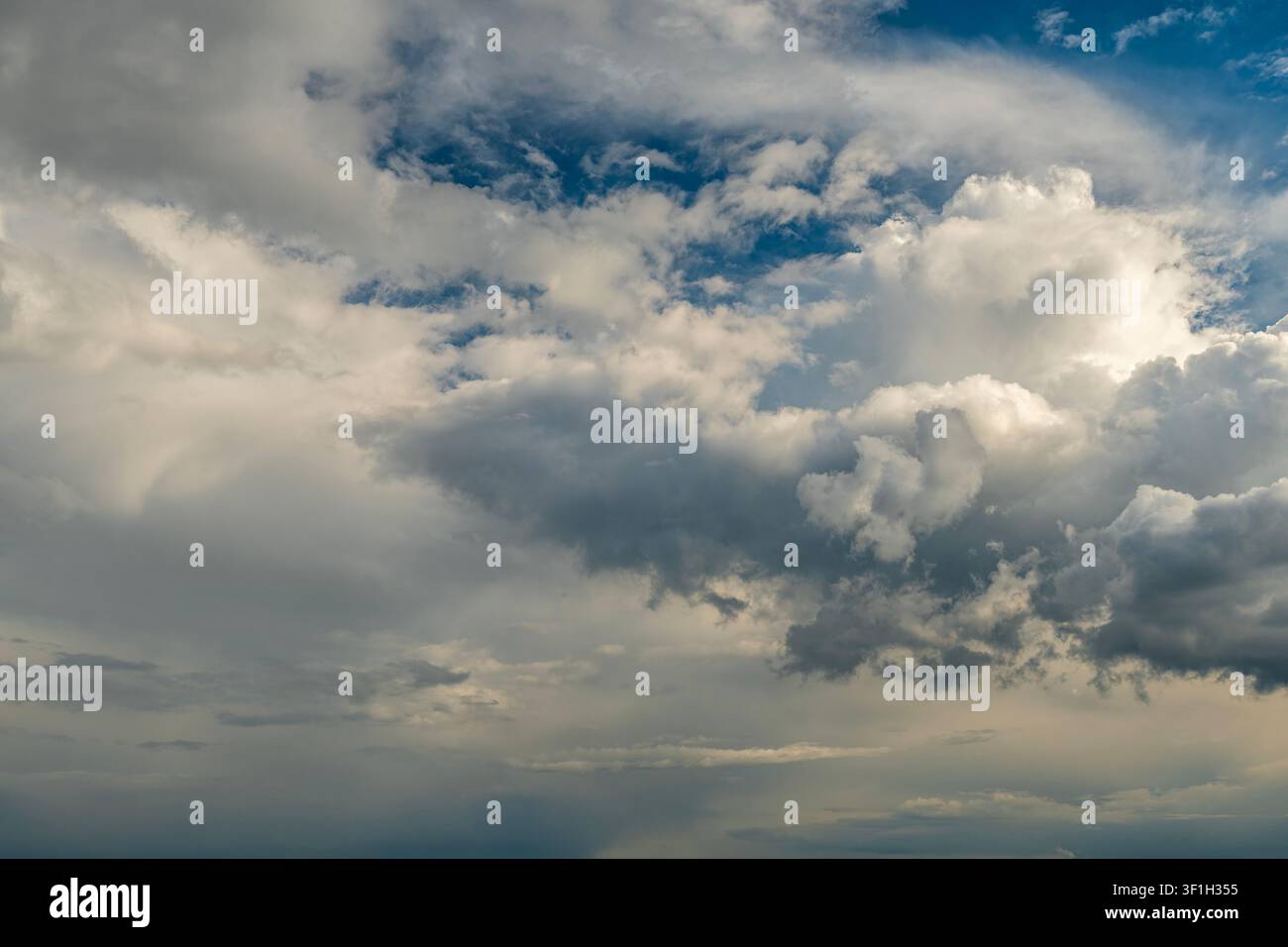 Dramatic storm clouds spreading across blue sky before rain Stock Photo