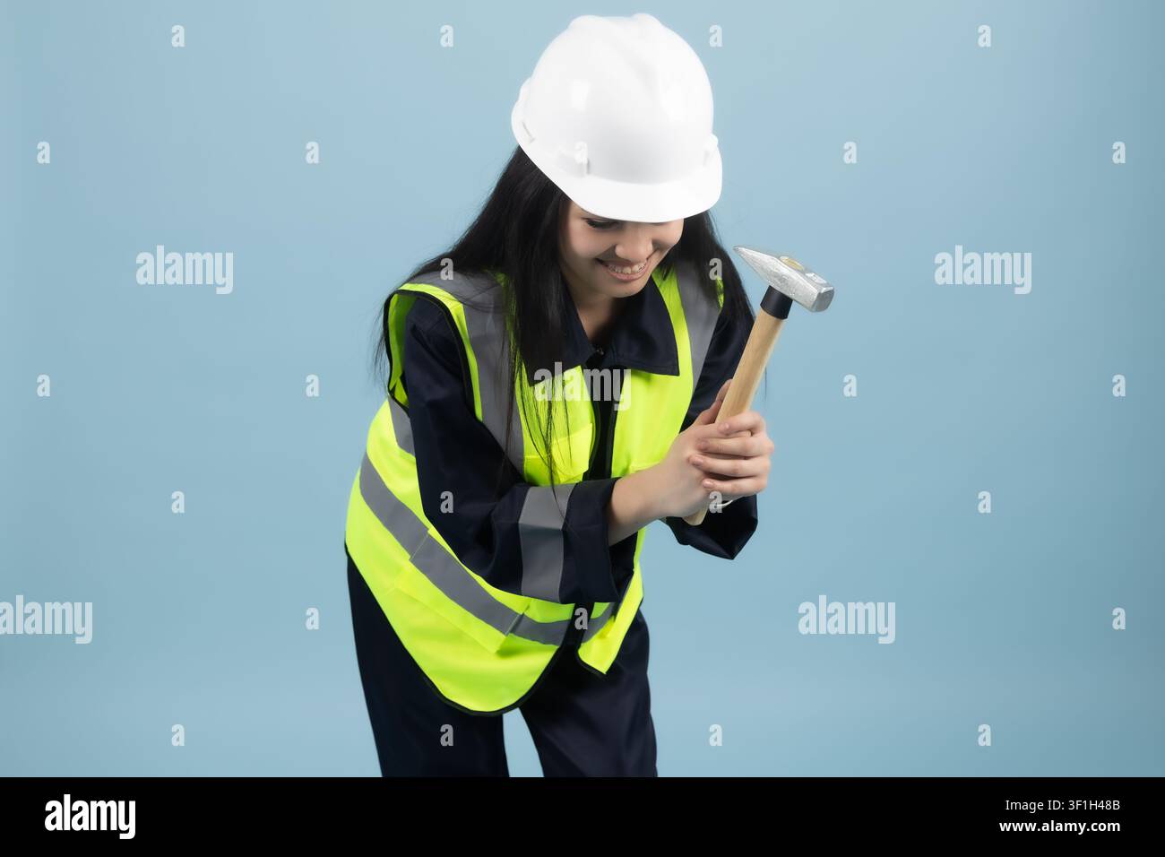 Female construction worker holding drill tool ready for renovation work Stock Photo