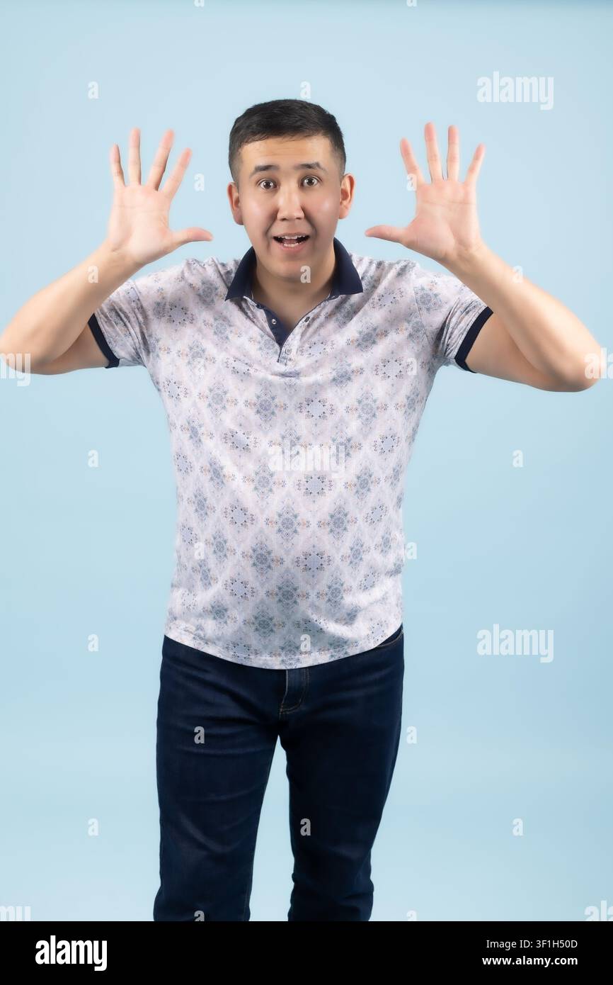 Young male holding hands up showing surprise and shock expression Stock Photo