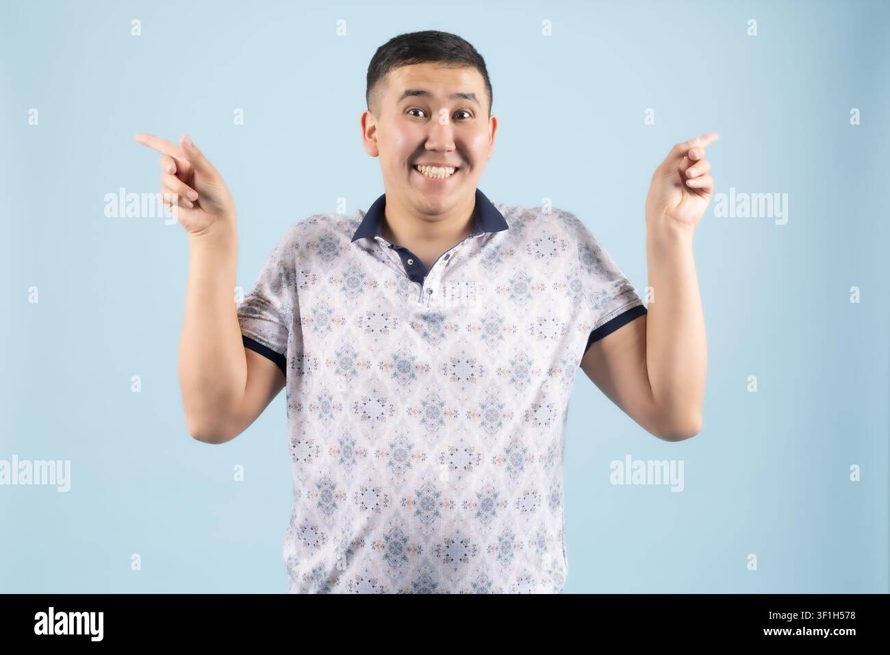 Surprised young man looking up with open hands and raised eyebrows Stock Photo