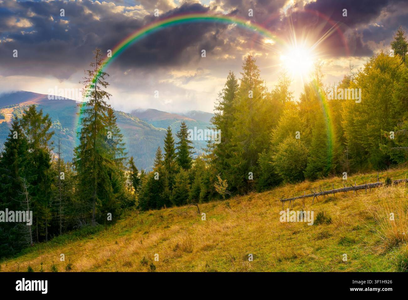 sunset over mountain landscape ukraine with spruce forest. rural valley of podobovets in the distance. evenning sky. serotinal background for carpathi Stock Photo