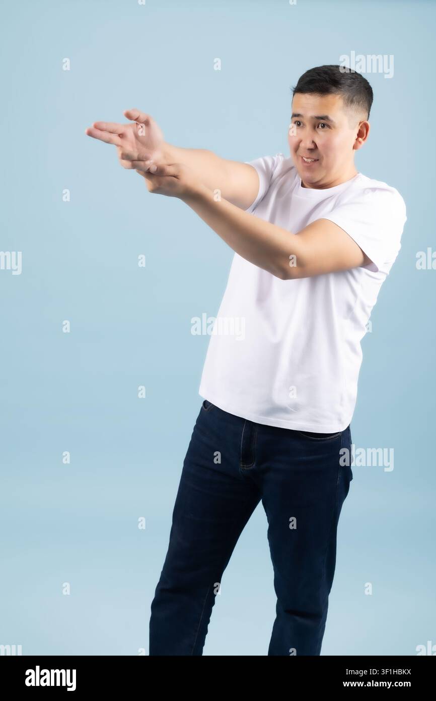 Young cheerful man pointing fingers forward directing your focus Stock Photo