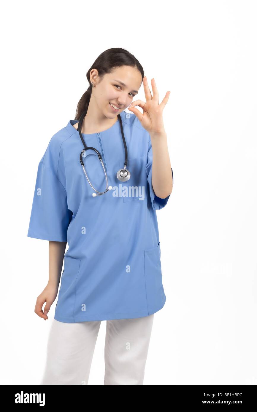 Young female medical nurse showing victory peace sign gesture Stock Photo