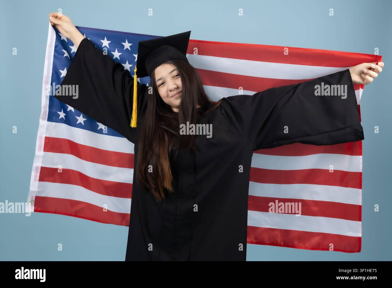 Proud female graduate holding the american flag behind her back Stock Photo