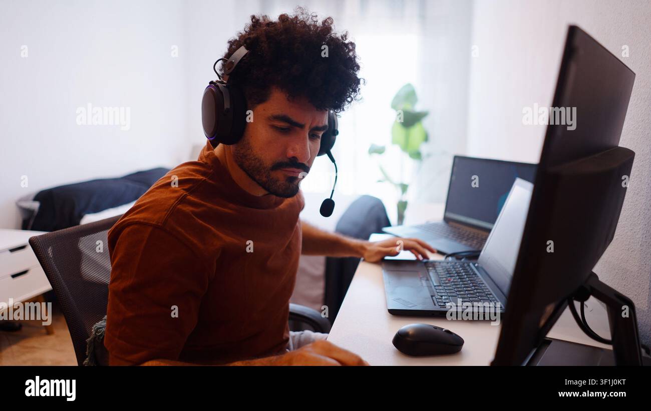 Young man working remotely from home at his computer setup Stock Photo