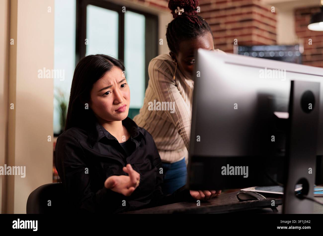 Engineers plan software security workflow while developing cloud computing data, HTML scripts and algorithms on a workplace computer inside an IT office. Stock Photo