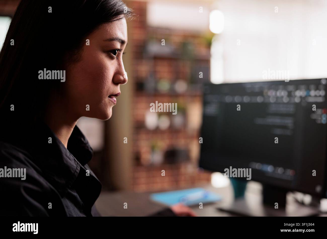 System engineer writes JavaScript terminal code on a terminal window while programming HTML, JavaScript and data algorithms for cloud computing inside a company office. Stock Photo