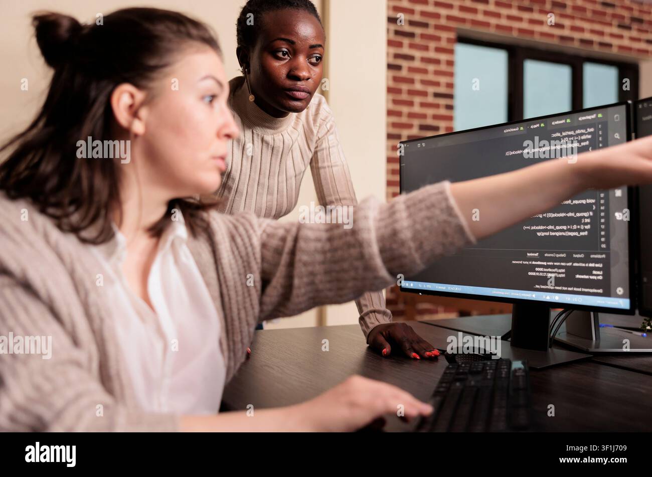 Diverse programmers writing HTML script on terminal window at an IT office desk, using screens, scripts and cloud computing tools for software engineering workflow. Stock Photo