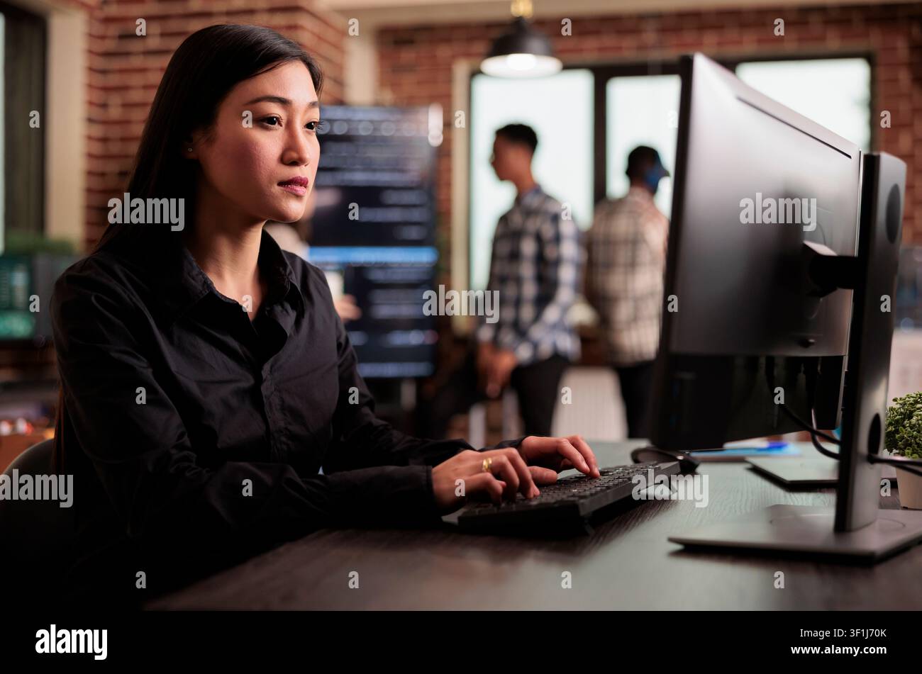 Asian programmer reviewing HTML script on terminal window at an IT office desk, using screens, scripts and cloud computing tools for software engineering workflow. Stock Photo