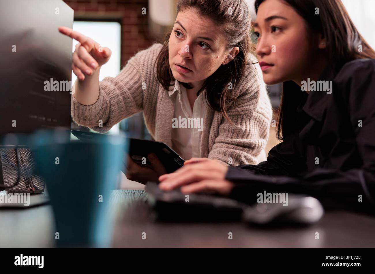 System engineers discuss a cloud coding project in a software office, collaborating on programming algorithms and user interface development. Stock Photo