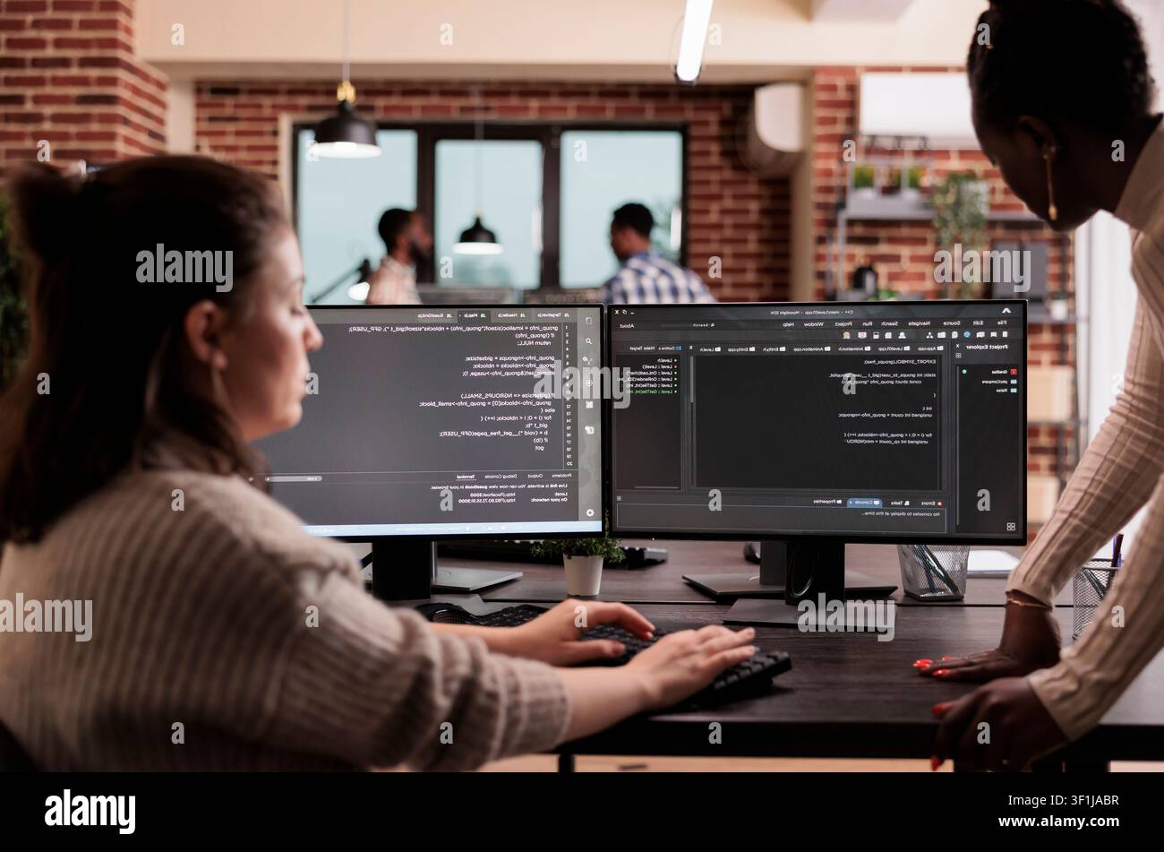 Programming engineers write code on computers to develop algorithm programs, user interface scripts and terminal workflow inside a software development company. Stock Photo