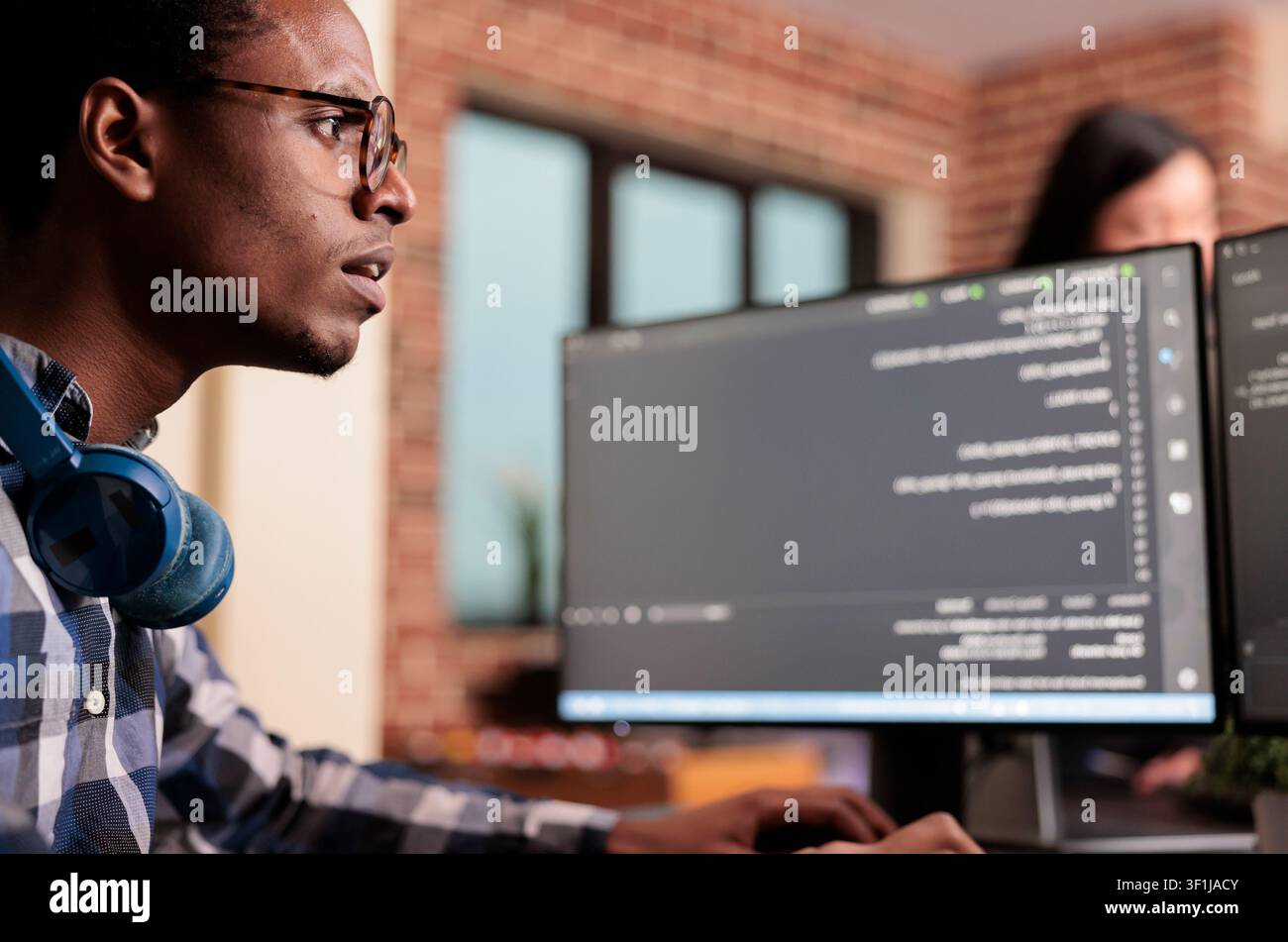 System engineer typing machine learning server code on computer, sitting at desk in software company. Programming engineer working on database system with coding script in it security agency. Stock Photo
