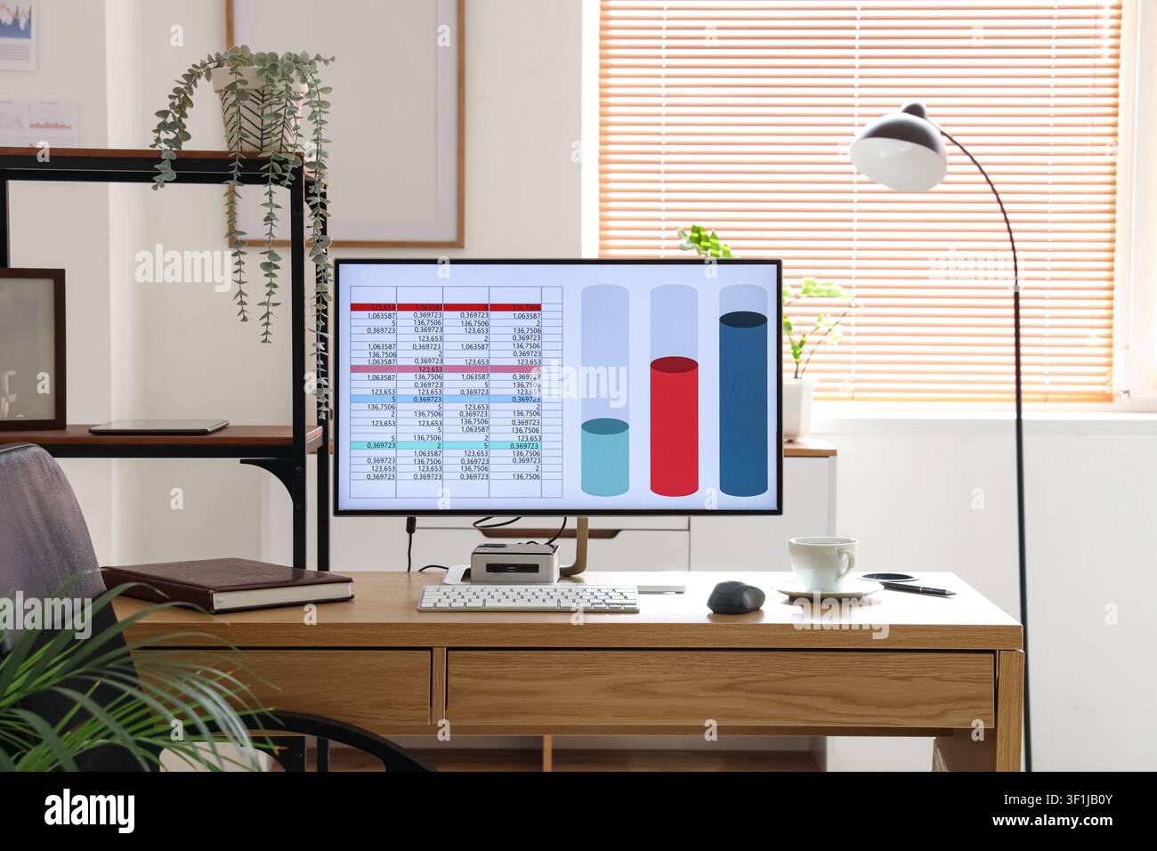 Computer with chart on desk in data scientists office Stock Photo