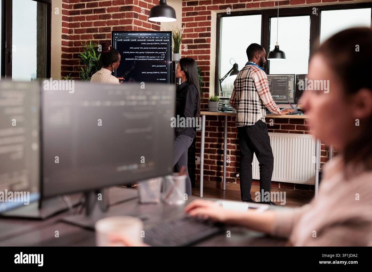 Developers analyze machine learning application code, combining programming code, software teamwork and digital infrastructure inside a technology office. Stock Photo
