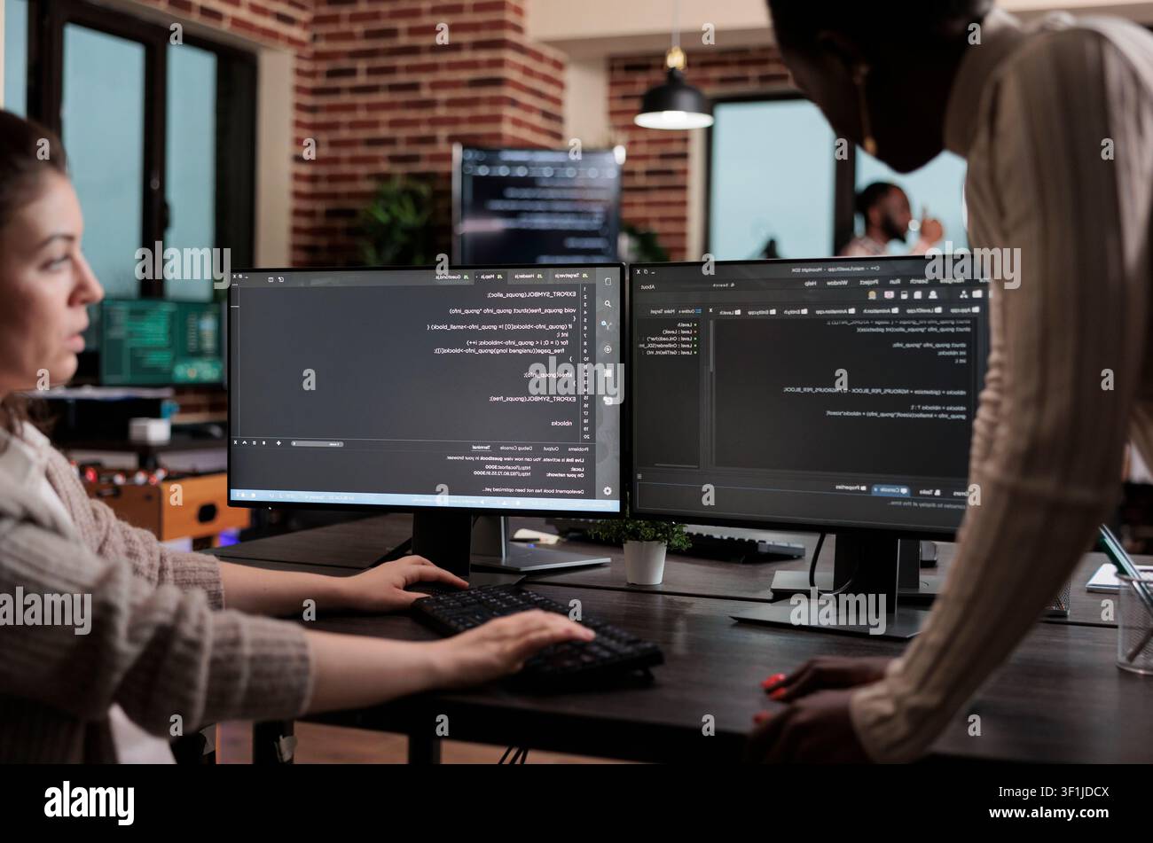 Diverse cybersecurity employees optimize mainframe processing methods and defend a database system by developing an advanced firewall mechanism. Stock Photo