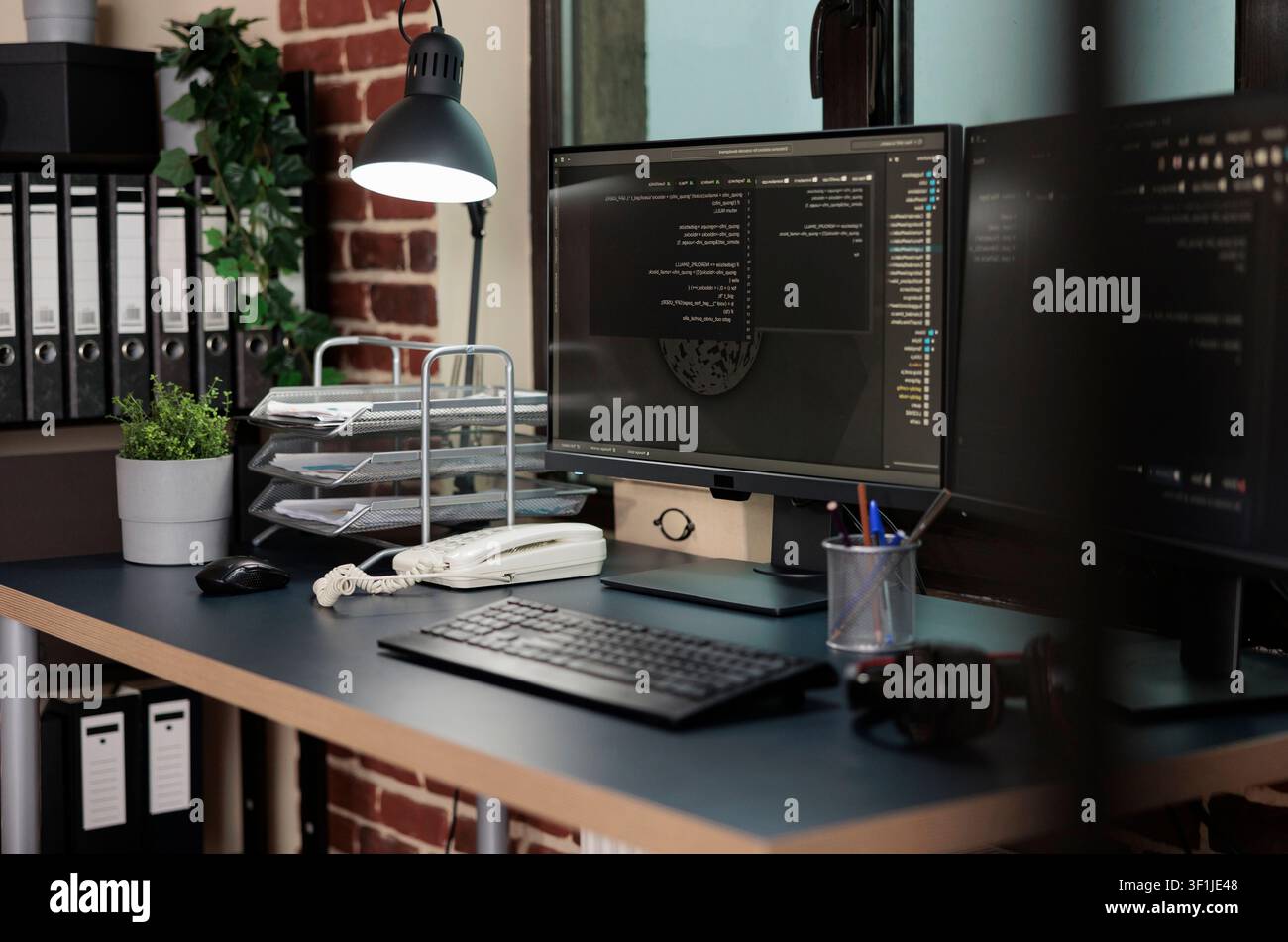 Empty office contains multiple computer displays with programming data, software information and integrated algorithms for secure technical work. Stock Photo