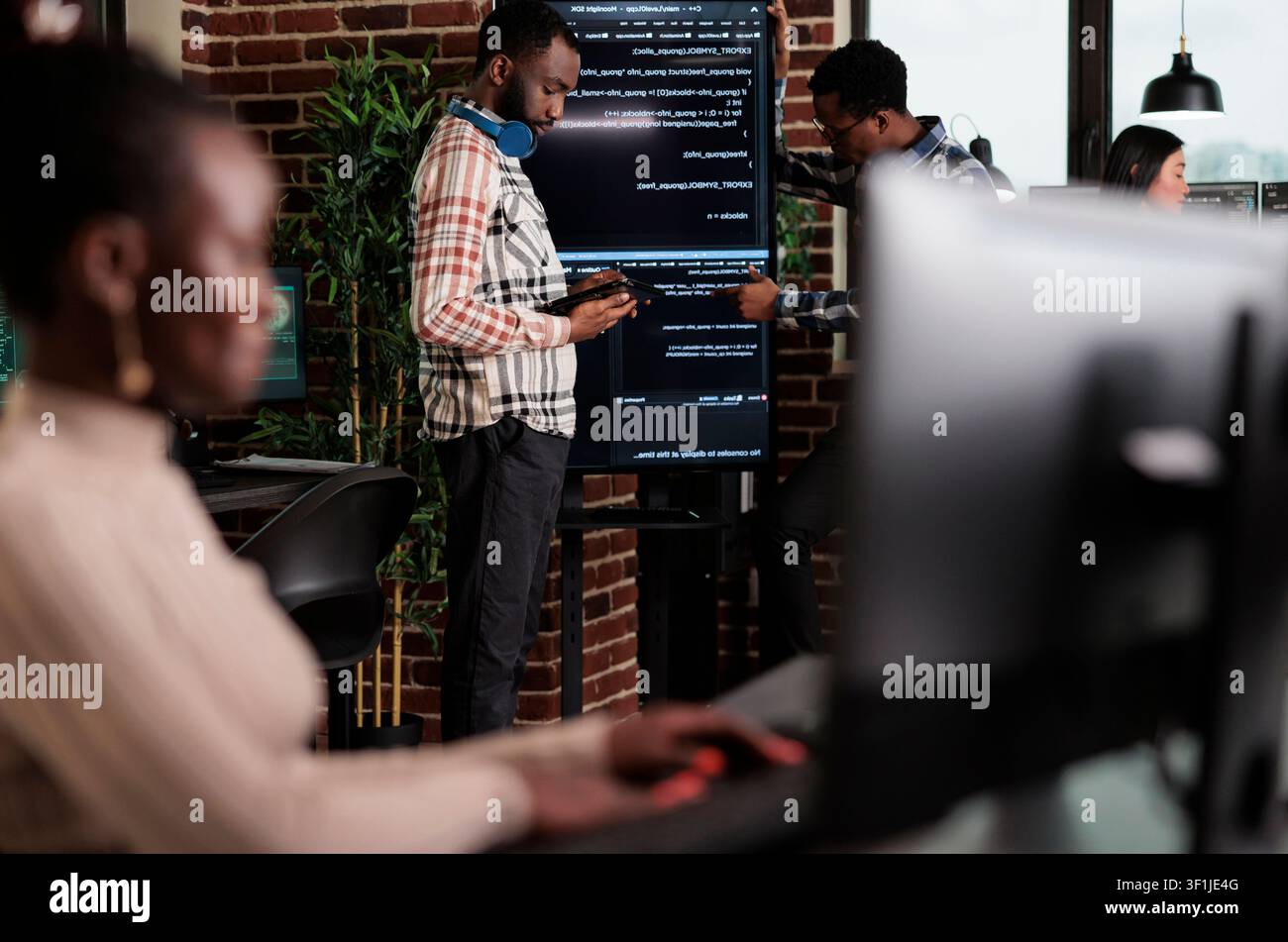 Programmer team searches for cyberattack sources and security coverage while developing encryption applications for digital protection. Stock Photo