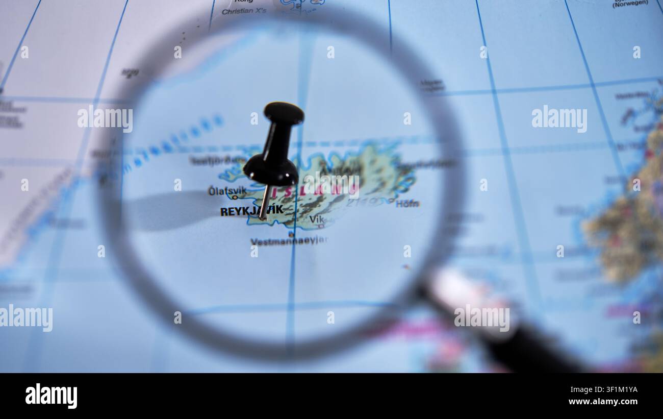 Reykjavik marked on a printed map, using a magnifying glass. Stock Photo