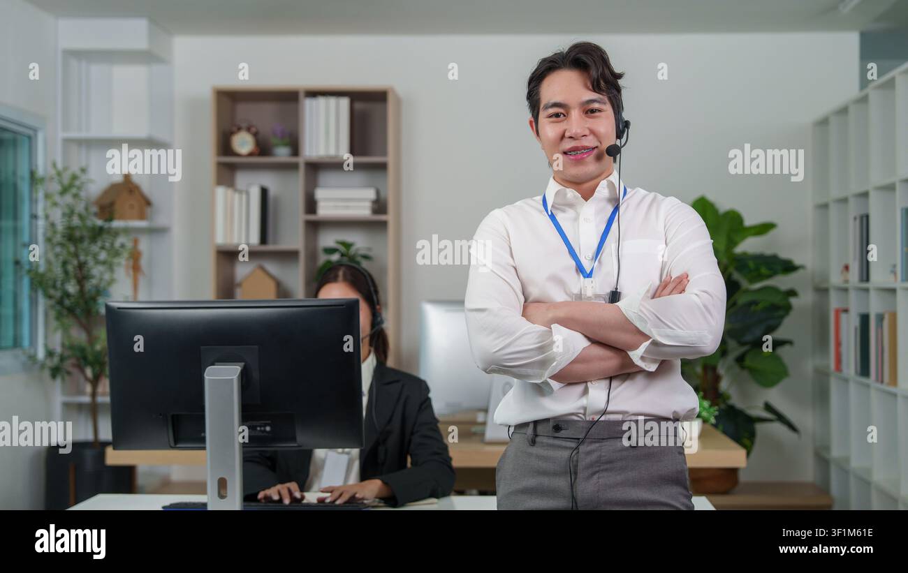 Confident Asian male customer service representative standing in office Stock Photo