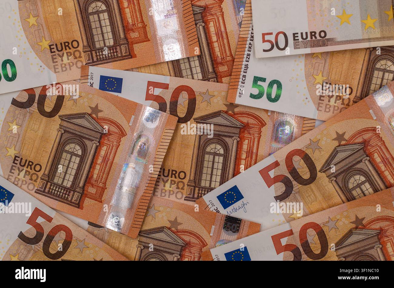 Close-up of multiple 50 euro banknotes arranged in an overlapping pattern, creating a detailed financial background. Stock Photo
