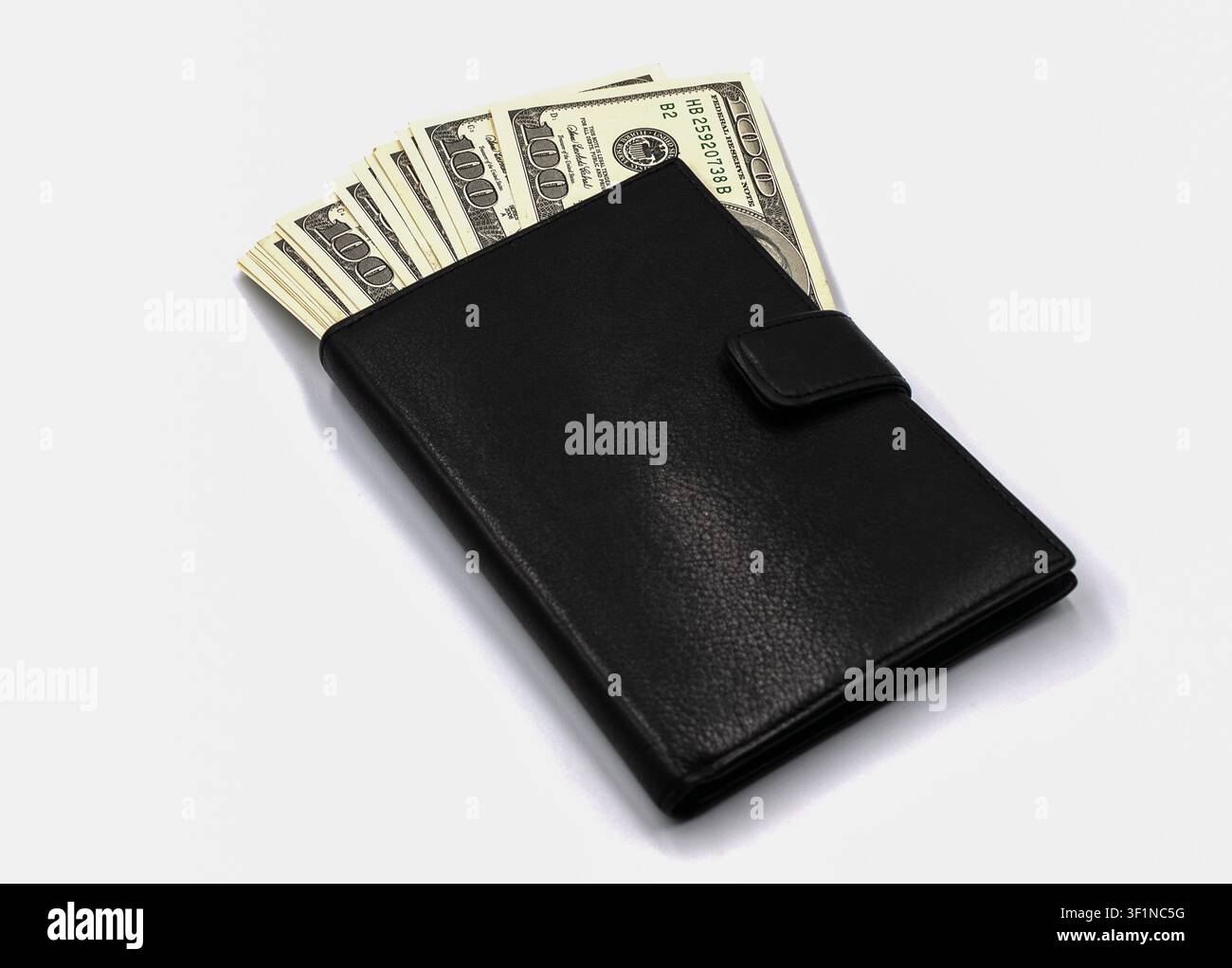 Black leather wallet full of hundred dollar bills on white background Stock Photo