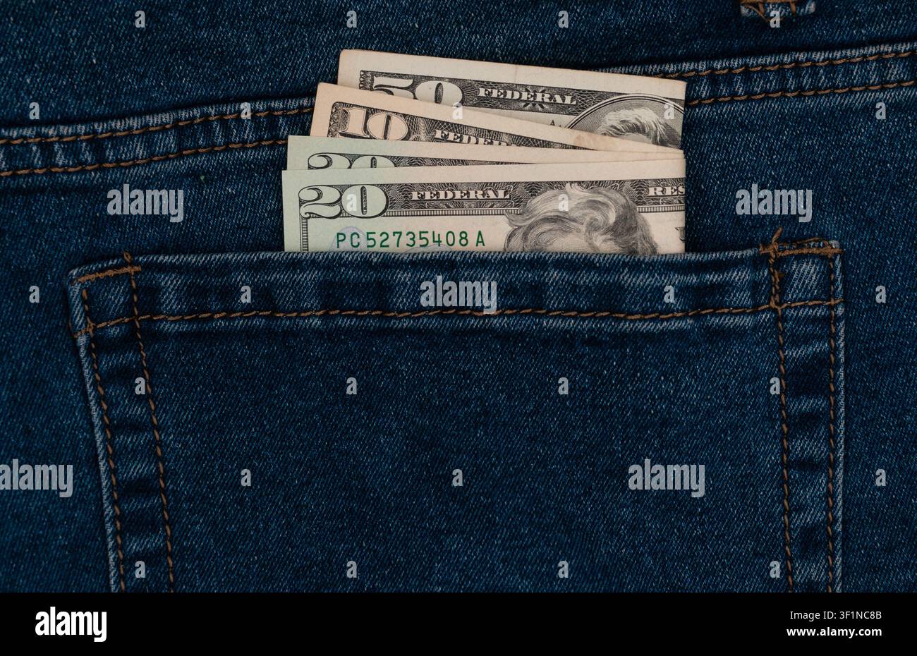 US dollar banknotes inside blue jeans back pocket Stock Photo