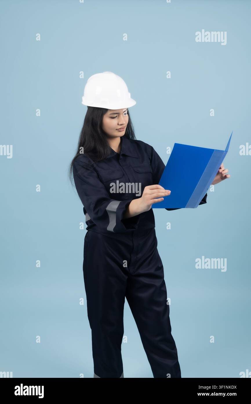 Female architect checking documents on a clipboard in the studio Stock Photo
