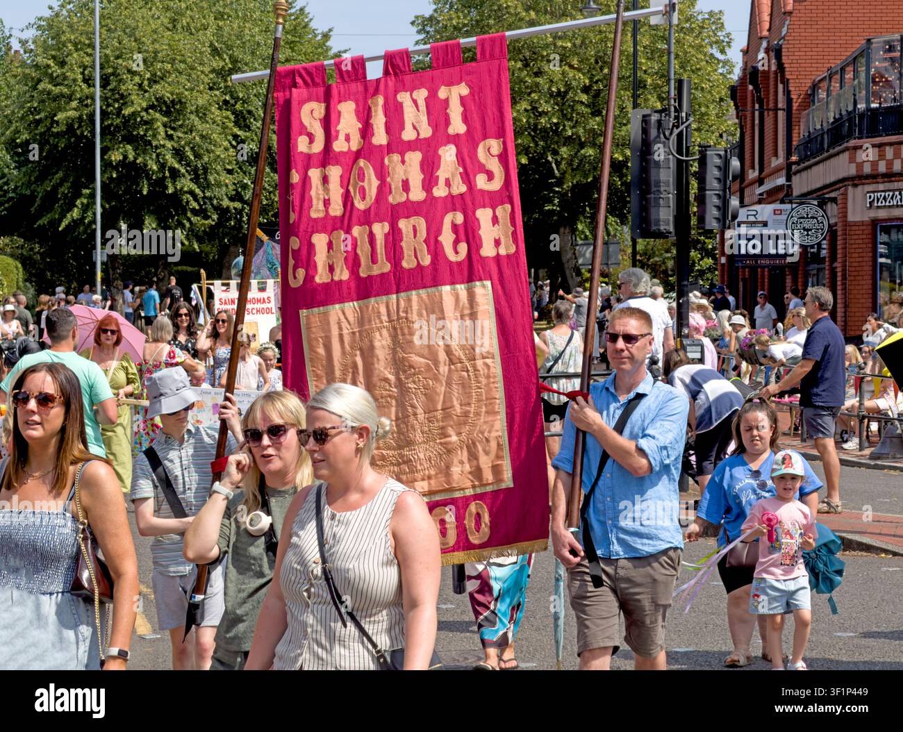 Red St Thomas Church banner and bearers join the annual Stockton Heath Walking Day procession on a sunny summer day July 2026 Stock Photo