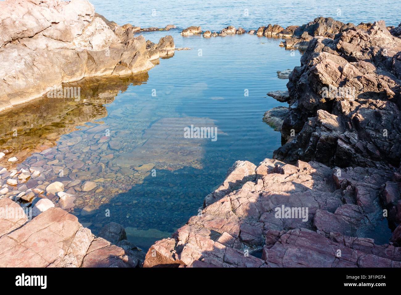 peaceful rock reflection in the sea water. calm summer vacation at the black sea. sunny weather Stock Photo