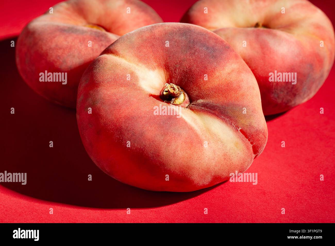 flat peaches on red background Stock Photo