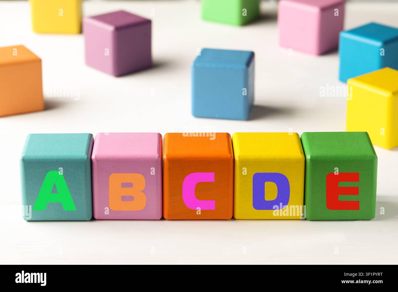 Learning alphabet. Wooden cubes with letters on white table Stock Photo