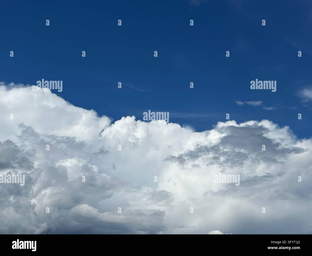 Blue sky filled with dramatic cumulus clouds Stock Photo
