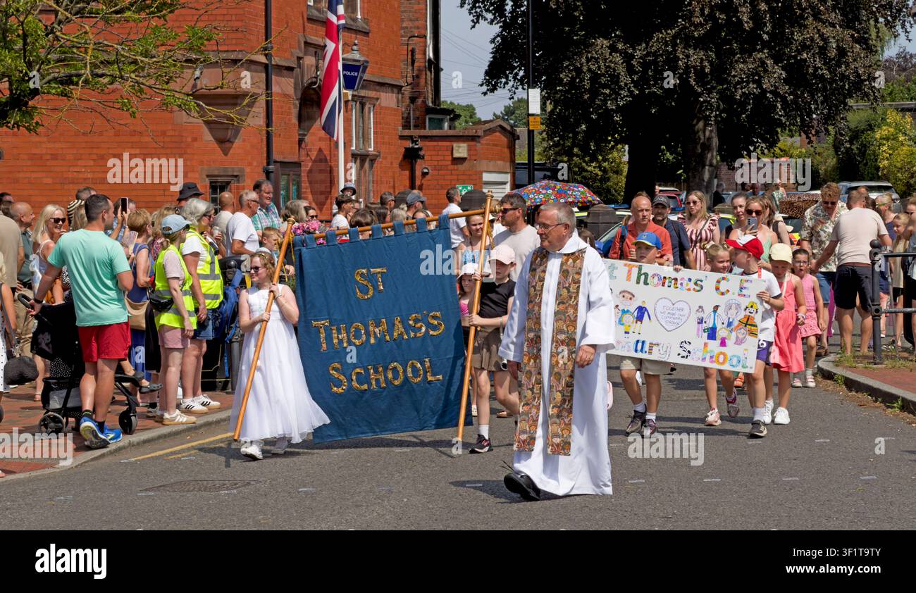 St Thomas’ CE Primary School joins Stockton Heath Walking Day in Warrington, led by a clergyman and school banner on 11 July 2026 Stock Photo