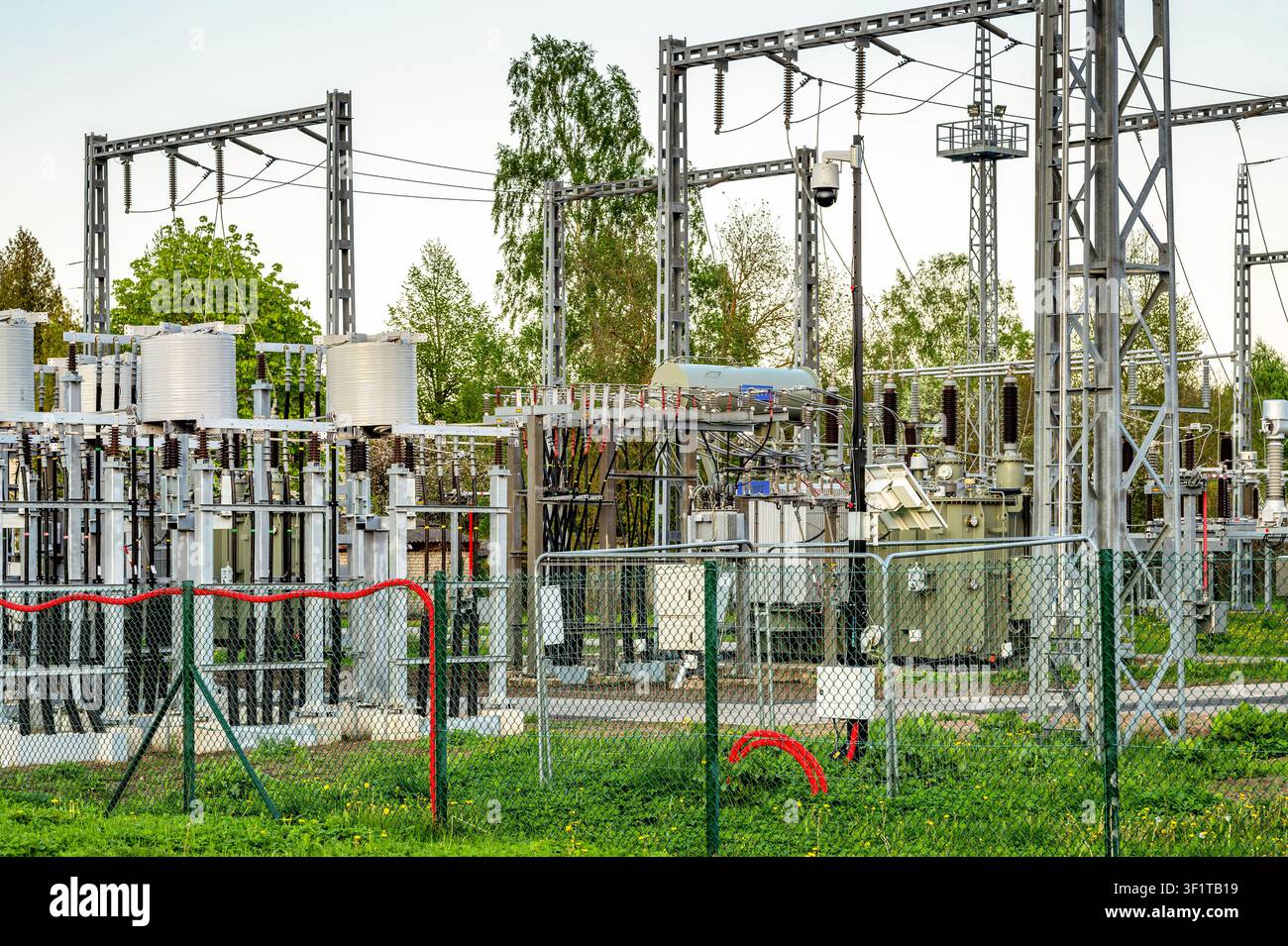 High voltage electrical substation with power transformers under modern security camera surveillance Stock Photo