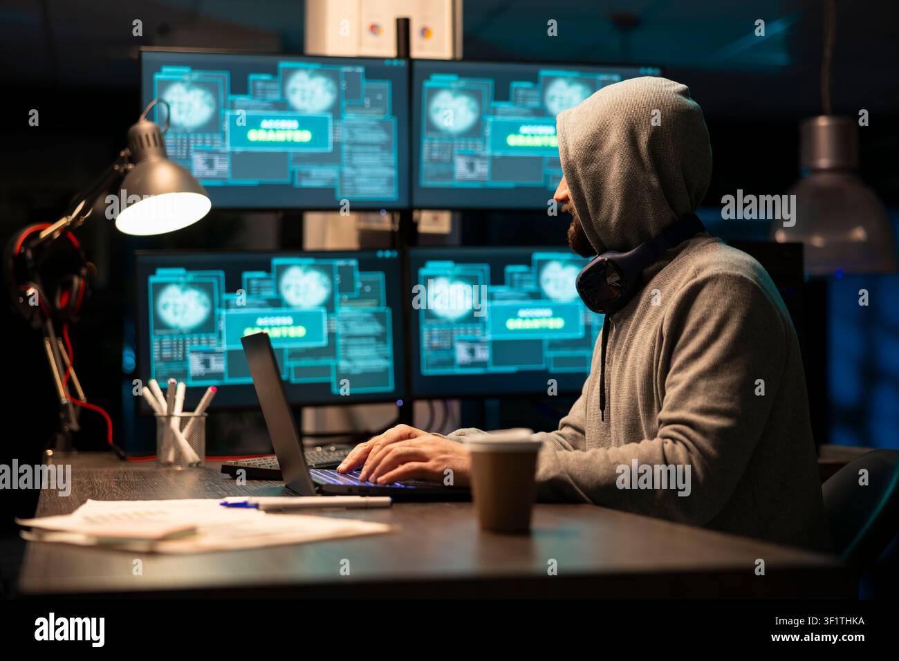Male developer works late night in online environment, typing code and debugging network systems for improved productivity. White man looks at monitors, focusing on cybersecurity and information safety Stock Photo
