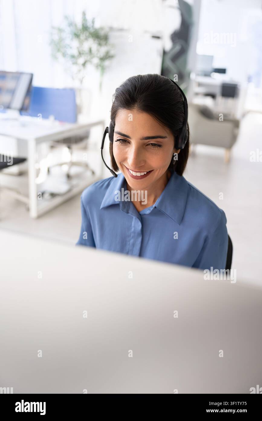 Smiling support agent assisting clients online Stock Photo