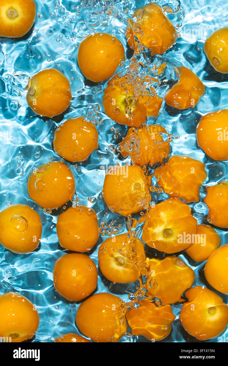Fresh physalis berries in water splash for refreshing food concept Stock Photo