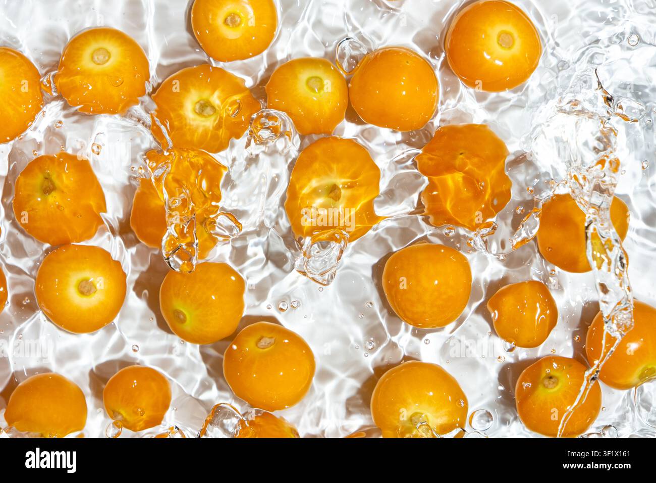 Fresh physalis berries in water splash for refreshing food concept Stock Photo