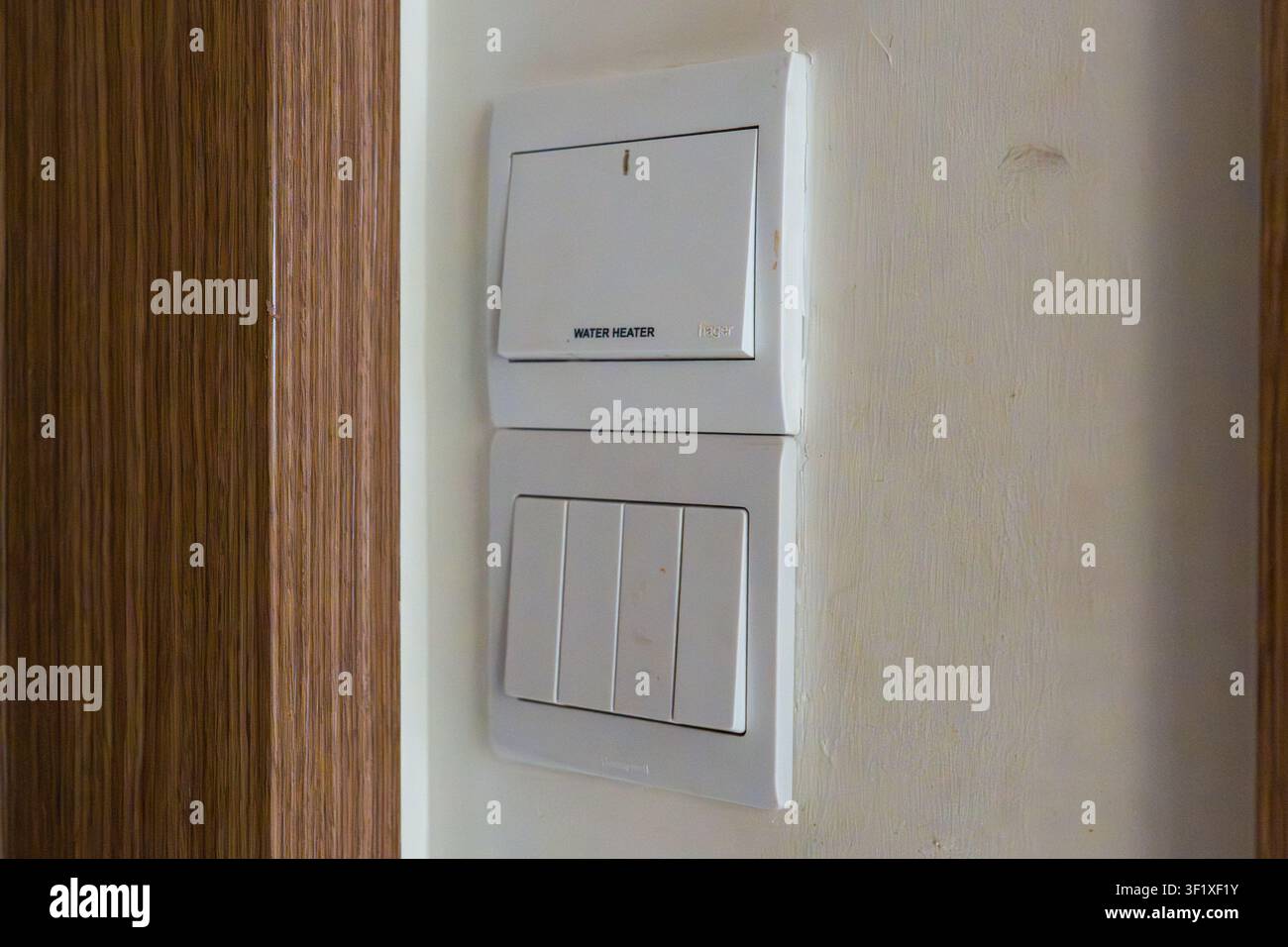 White wall-mounted light switch panel installed vertically. Modern design with two distinct toggle controls. Simple clean lines for easy use and insta Stock Photo