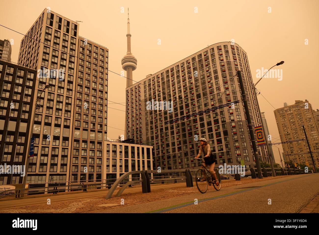 A woman bikes along the waterfront in Toronto as wildfire smoke fills