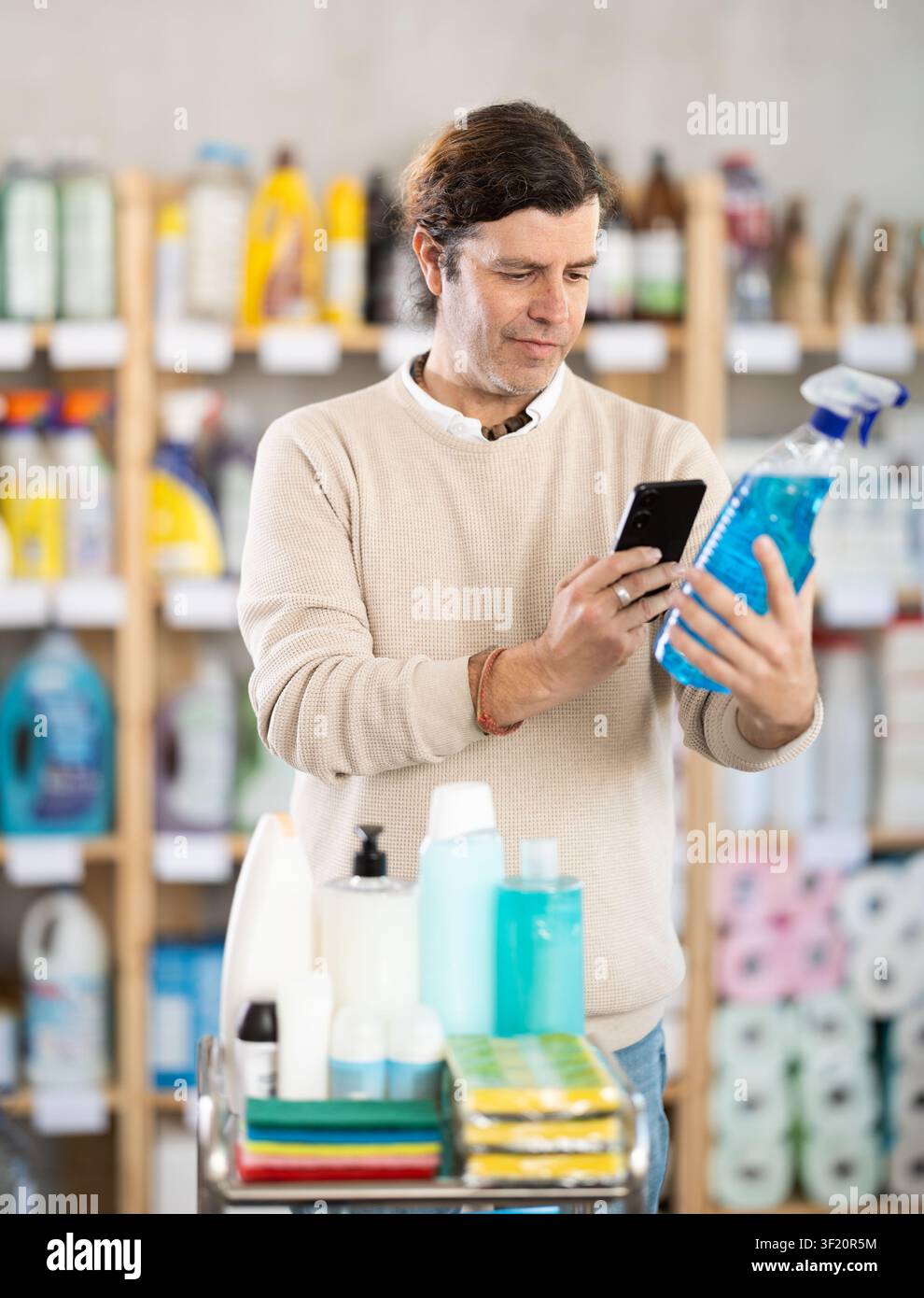 Middle-aged man scanning spray barcode in store Stock Photo