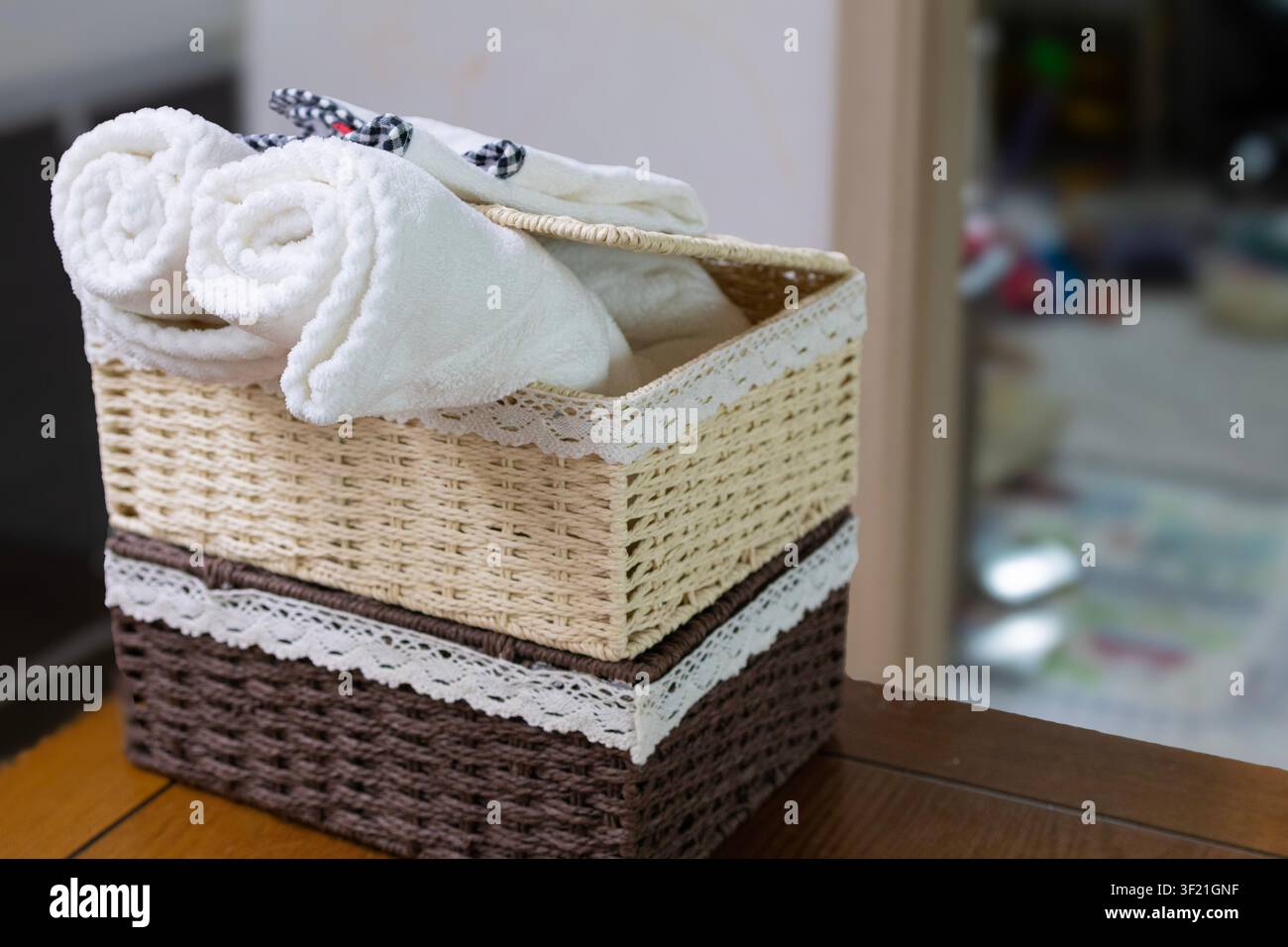 Rolled White Towels in Decorative Wicker Storage Basket at Home Stock Photo