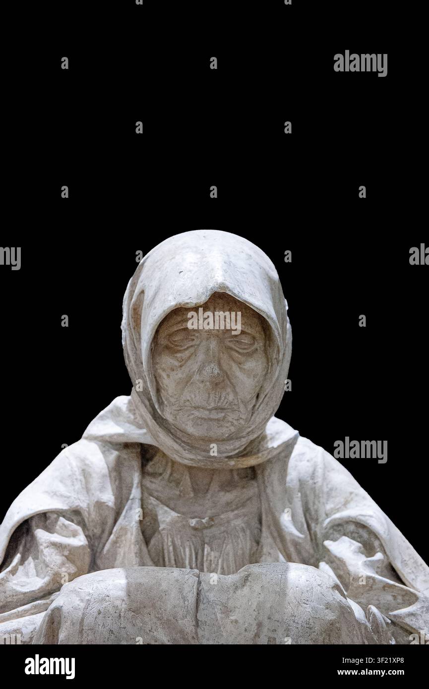 Marble sculpture of a hooded figure on a dark background Stock Photo