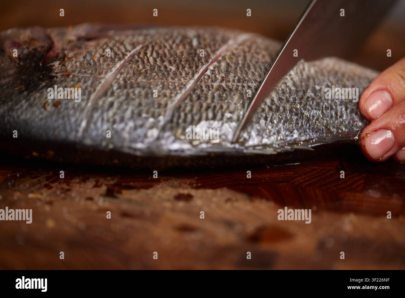Chef preparing raw sea bream for cooking Stock Photo