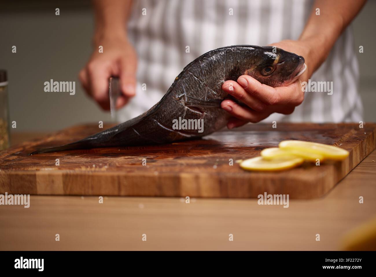 Chef preparing raw sea bream for cooking Stock Photo