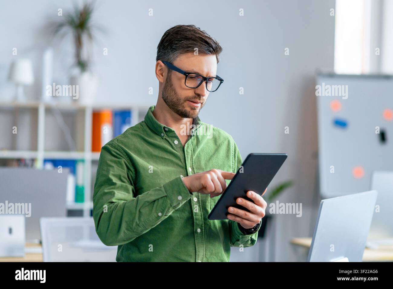 Man Using Tablet In Office, Focused On Work, Professional Concept Stock Photo