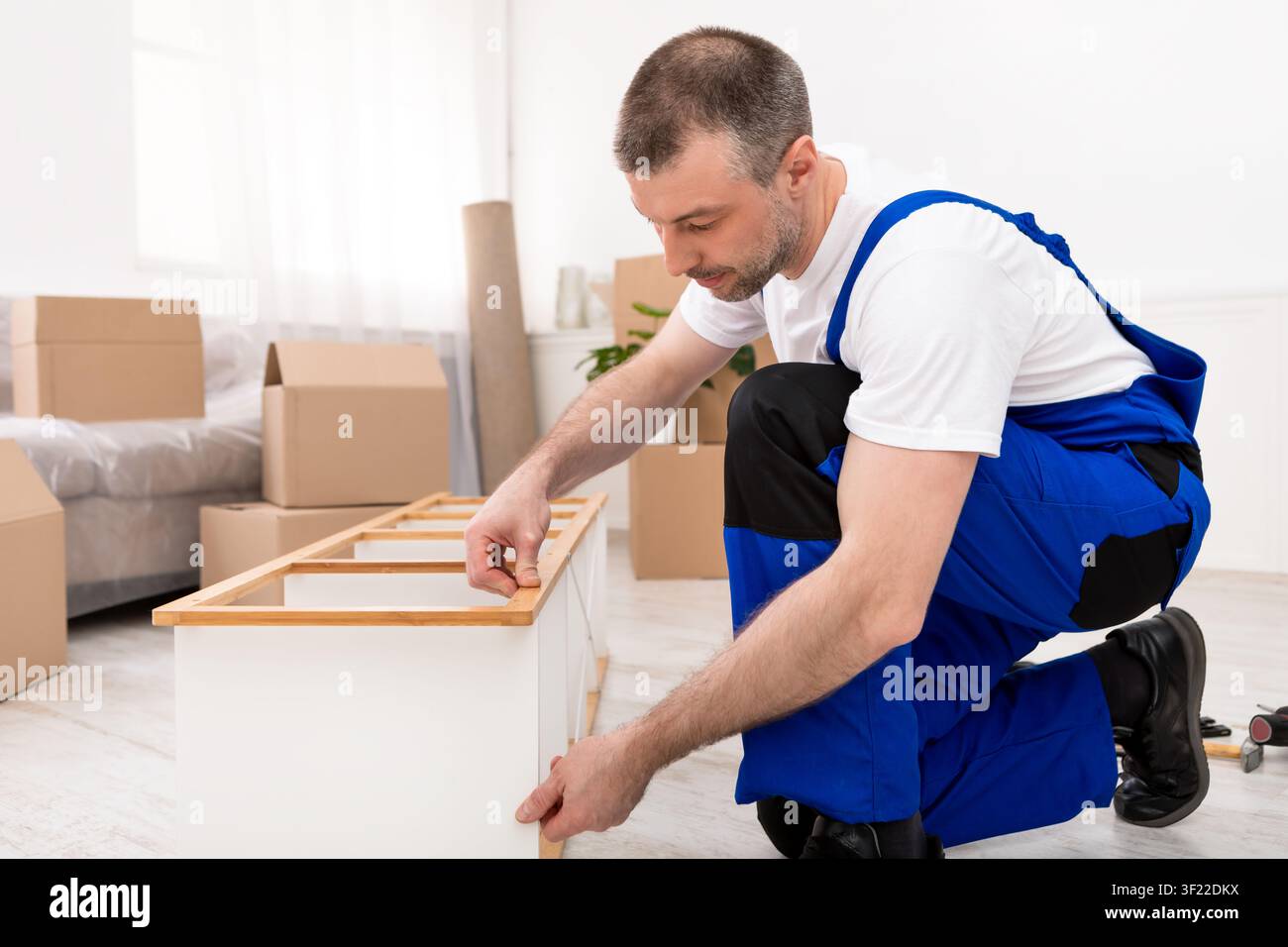 Professional Carpenter Man Repairing Shelf Assembling Furniture Indoors Stock Photo